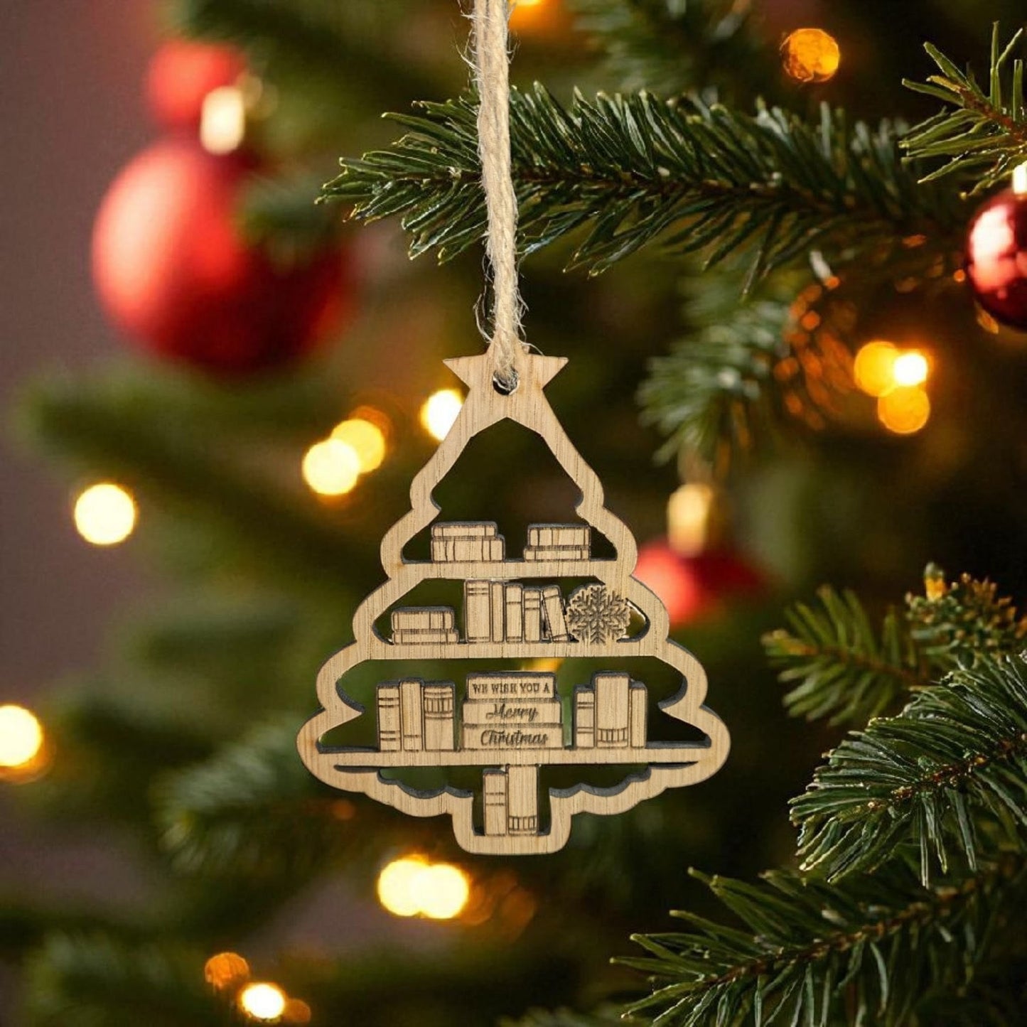 Decorative Christmas tree ornament with book design hanging on a Christmas tree.
