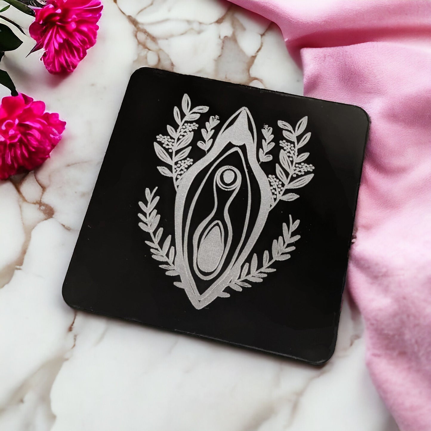 Sleek black wine coaster. Made with a lovely women empowerment design. Featuring a floral vagina in the middle