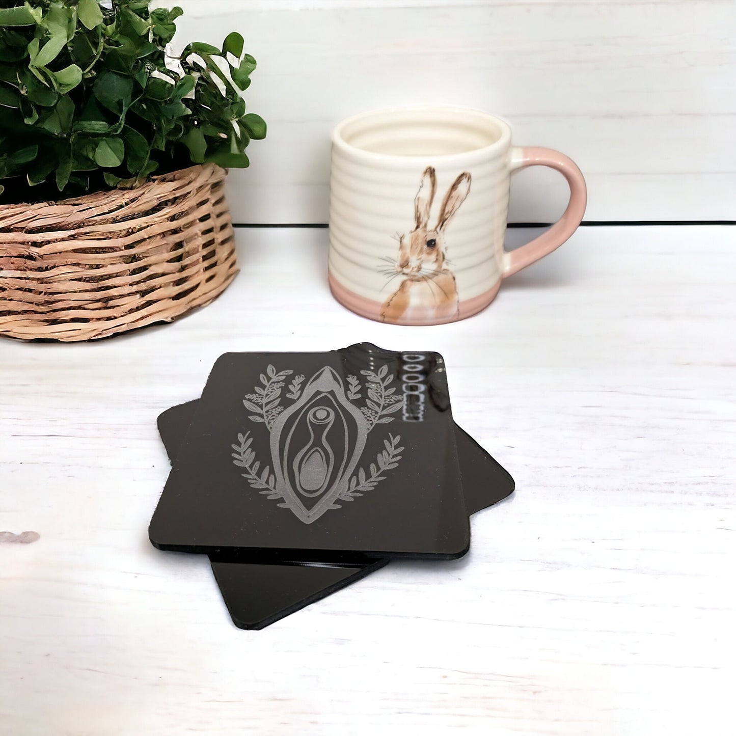 Stack of 2 vagina shaped coasters. With a foliage design behind the vulva. Beautiful vulva themed home gift