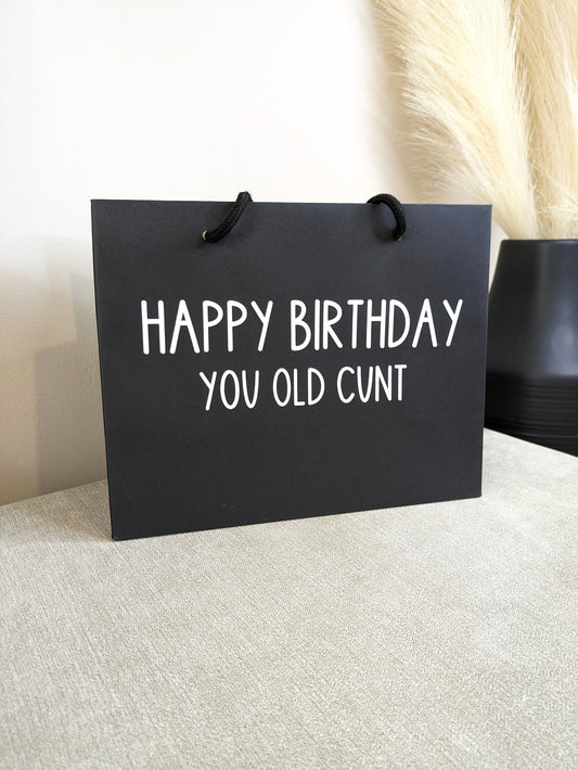 black gift bag with happy birthday you old cunt on it. Perfect for gifting to an old friend