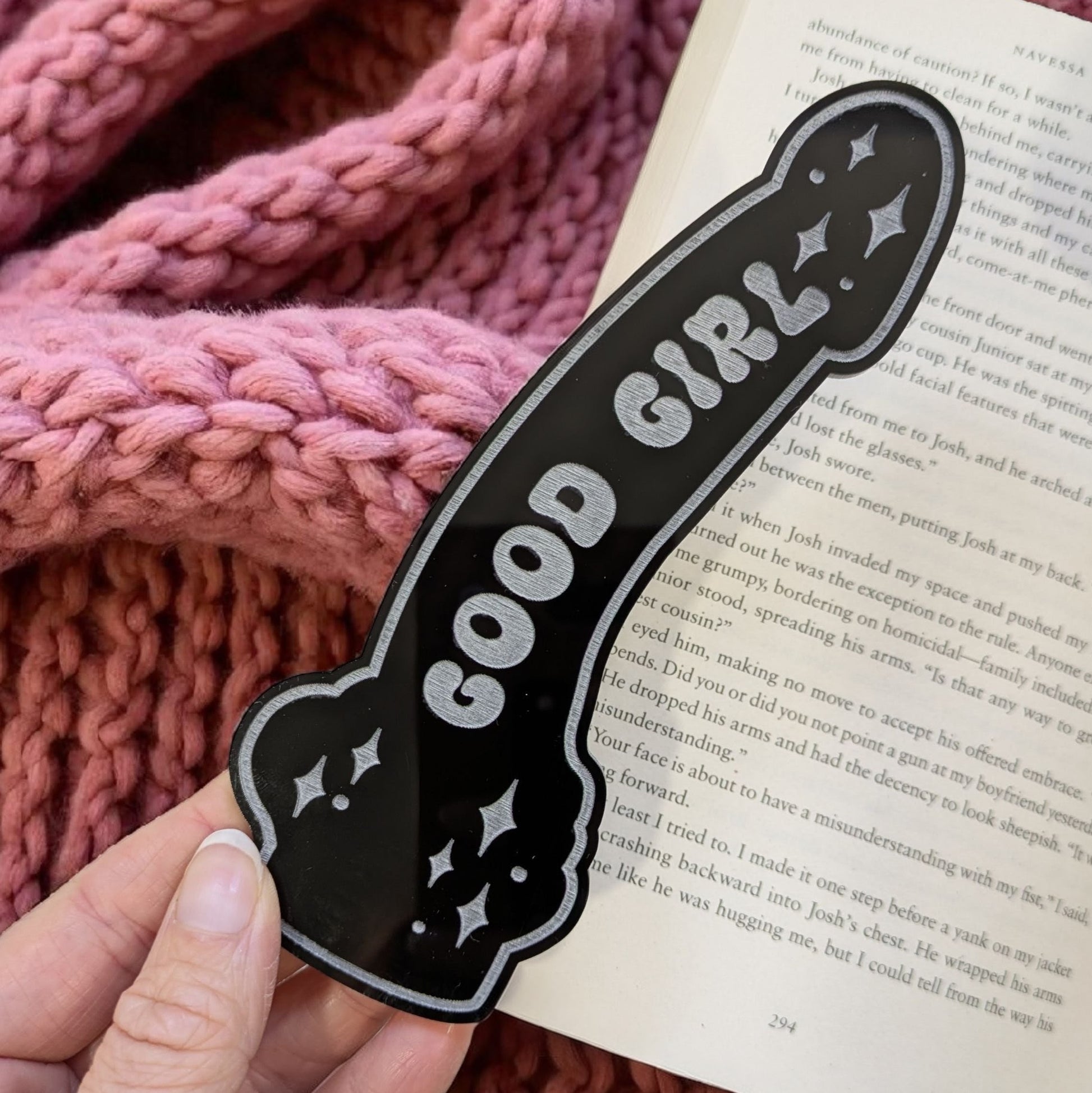 black bookmark made form acrylic with good girl engrvaed. On an open book