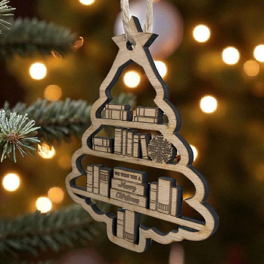 Wooden Christmas tree ornament with books and 'Merry Christmas' text on a blurred Christmas tree background.