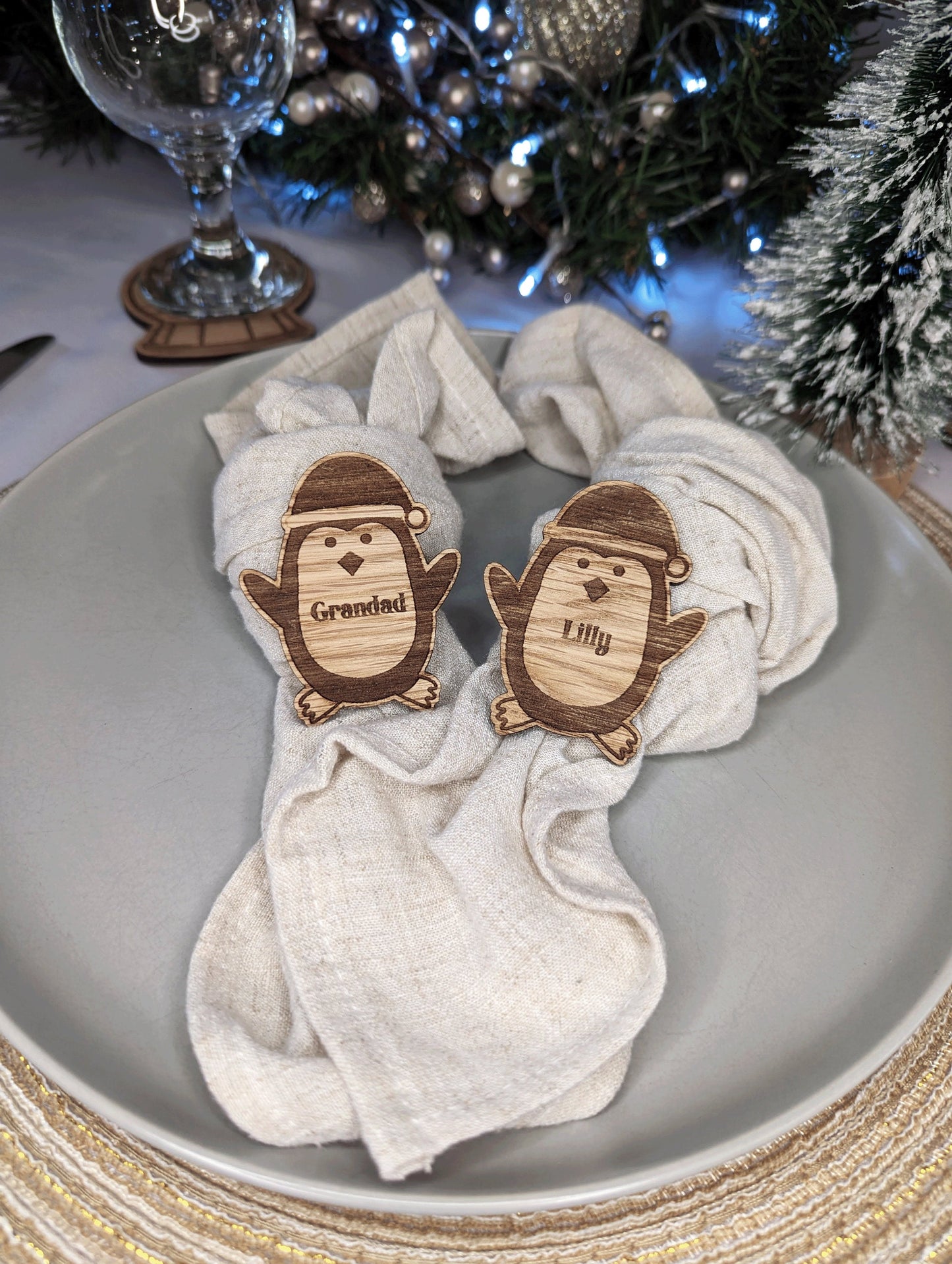 Oak penguin in the middle of a christmas plate. With a name engraved in the middle as a name card.