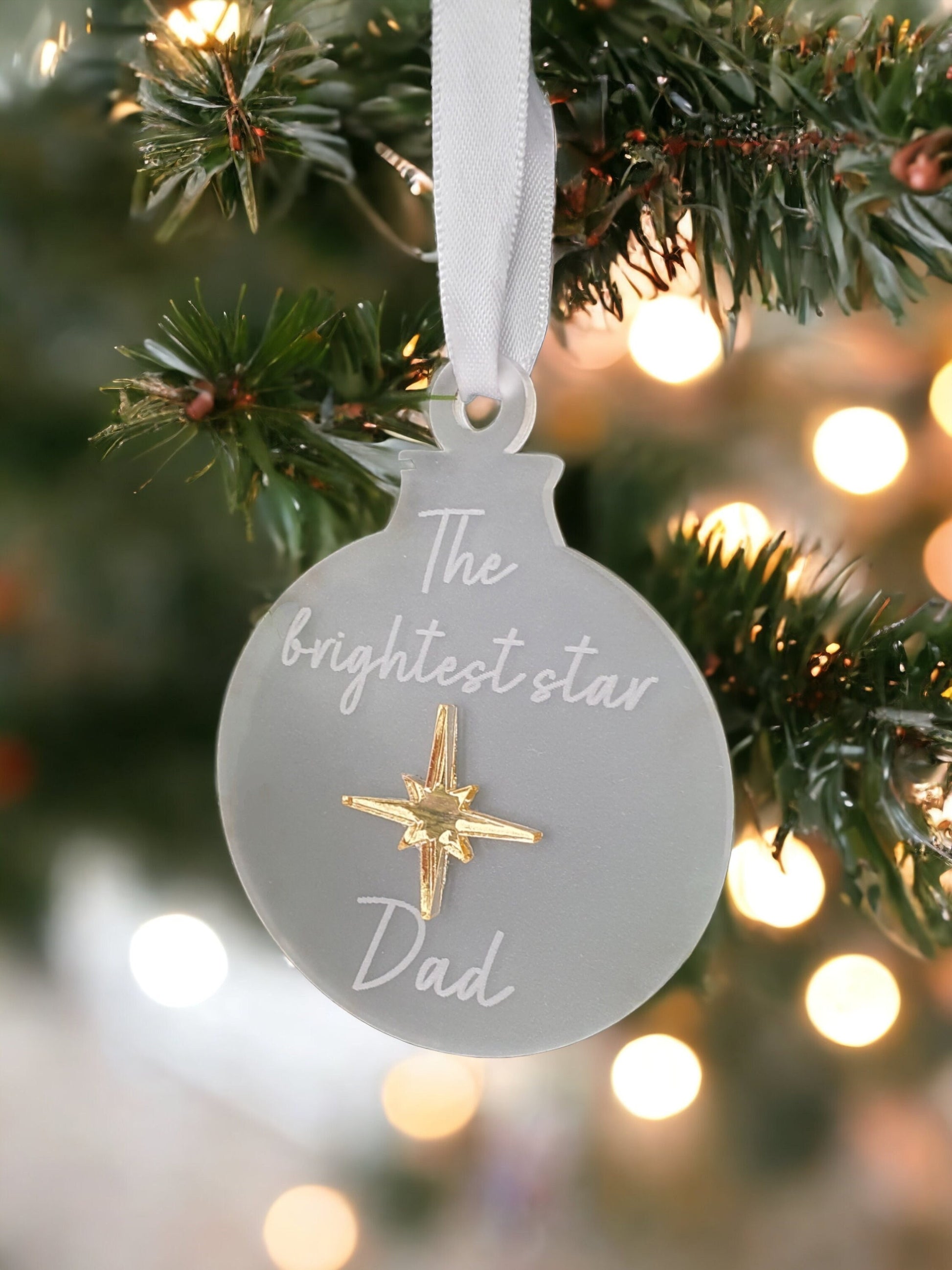 a frosted christmas decoration with the brightest star engraved in it. Made with a beautiful gold star for a memorial decoration for a dad. 