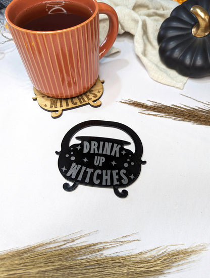 cauldron shaped home decor coaster. Drink up witches is engraved in to the acrylic coaster