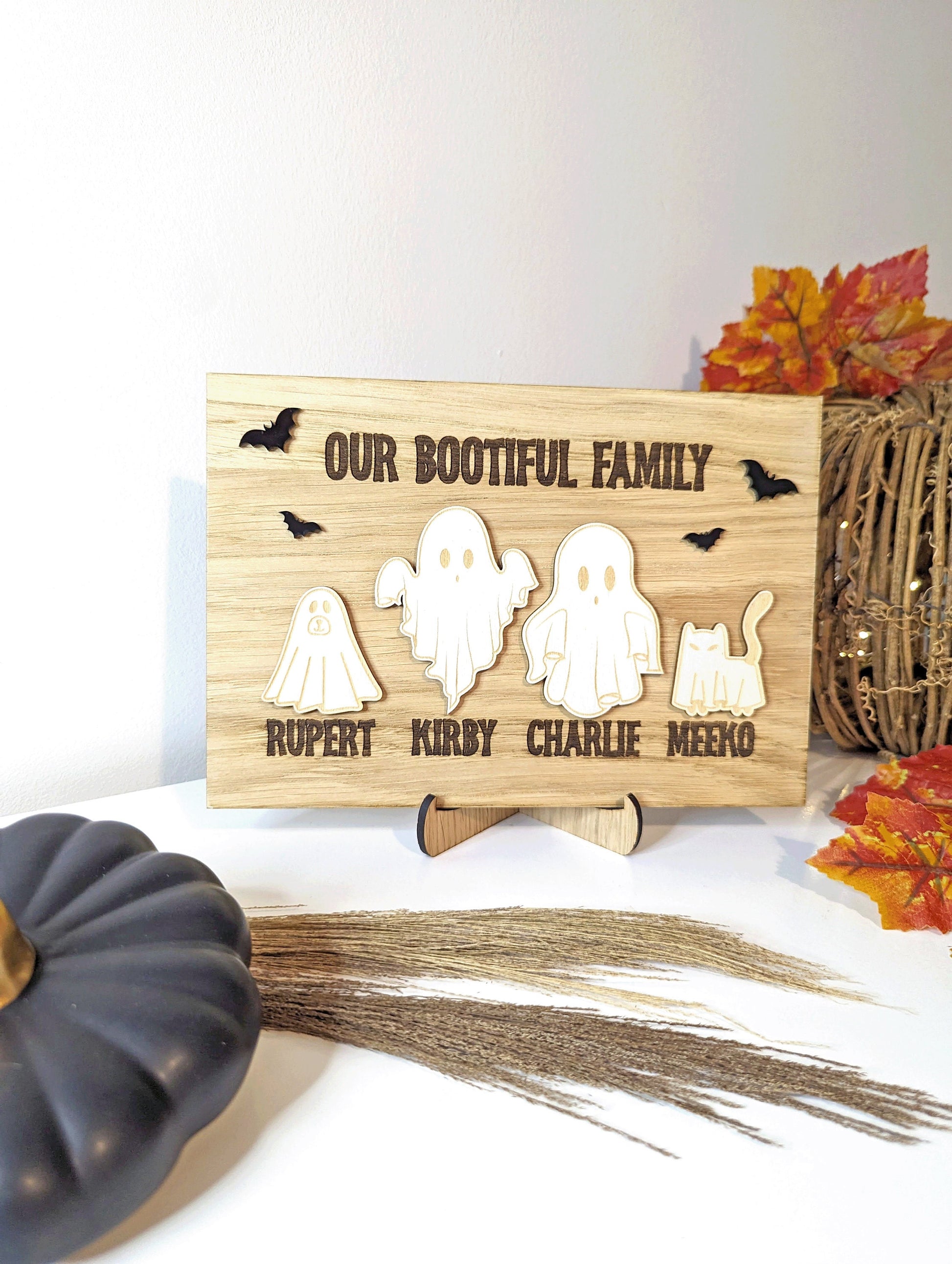 oak halloween sign with 4 different ghosts. Family names are engraved below wooden ghosts. 