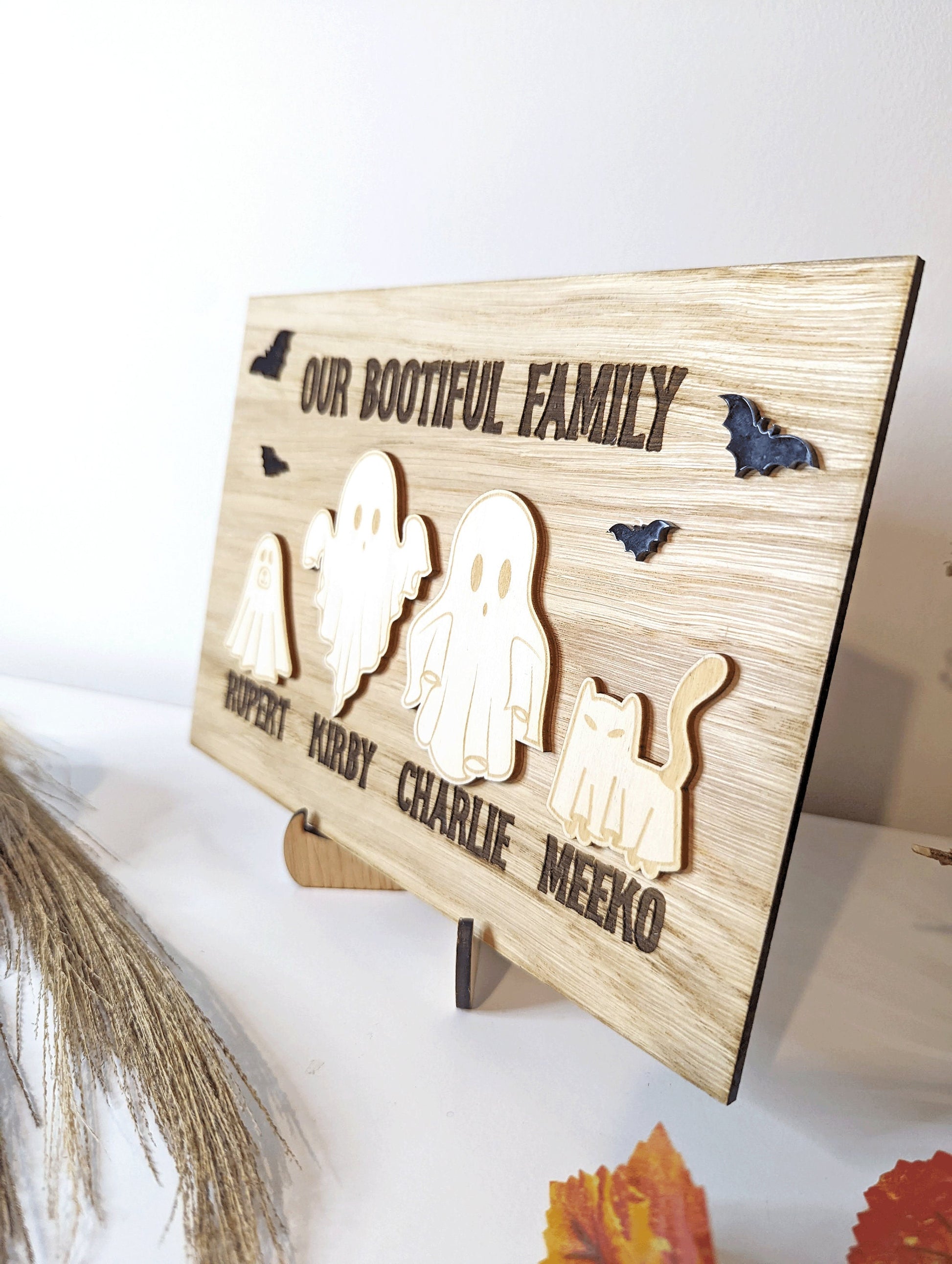 Halloween family tree sign. Made with 2 different types of wood. Featuring personalised ghost cat and dog. Stood up with the included stand.