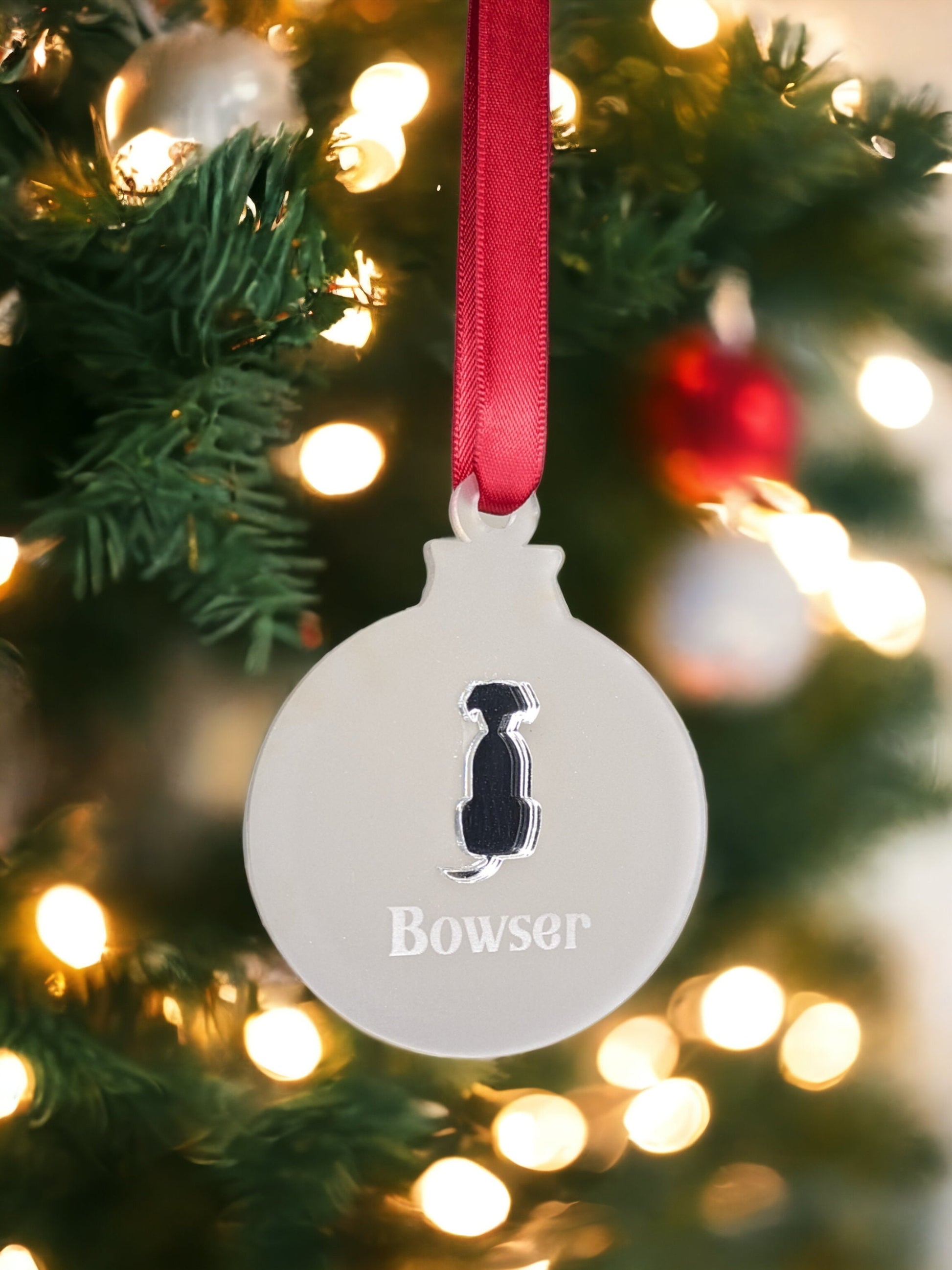 Silver mirror dog themed bauble with red ribbon. Pets name is engraved into the circle bauble