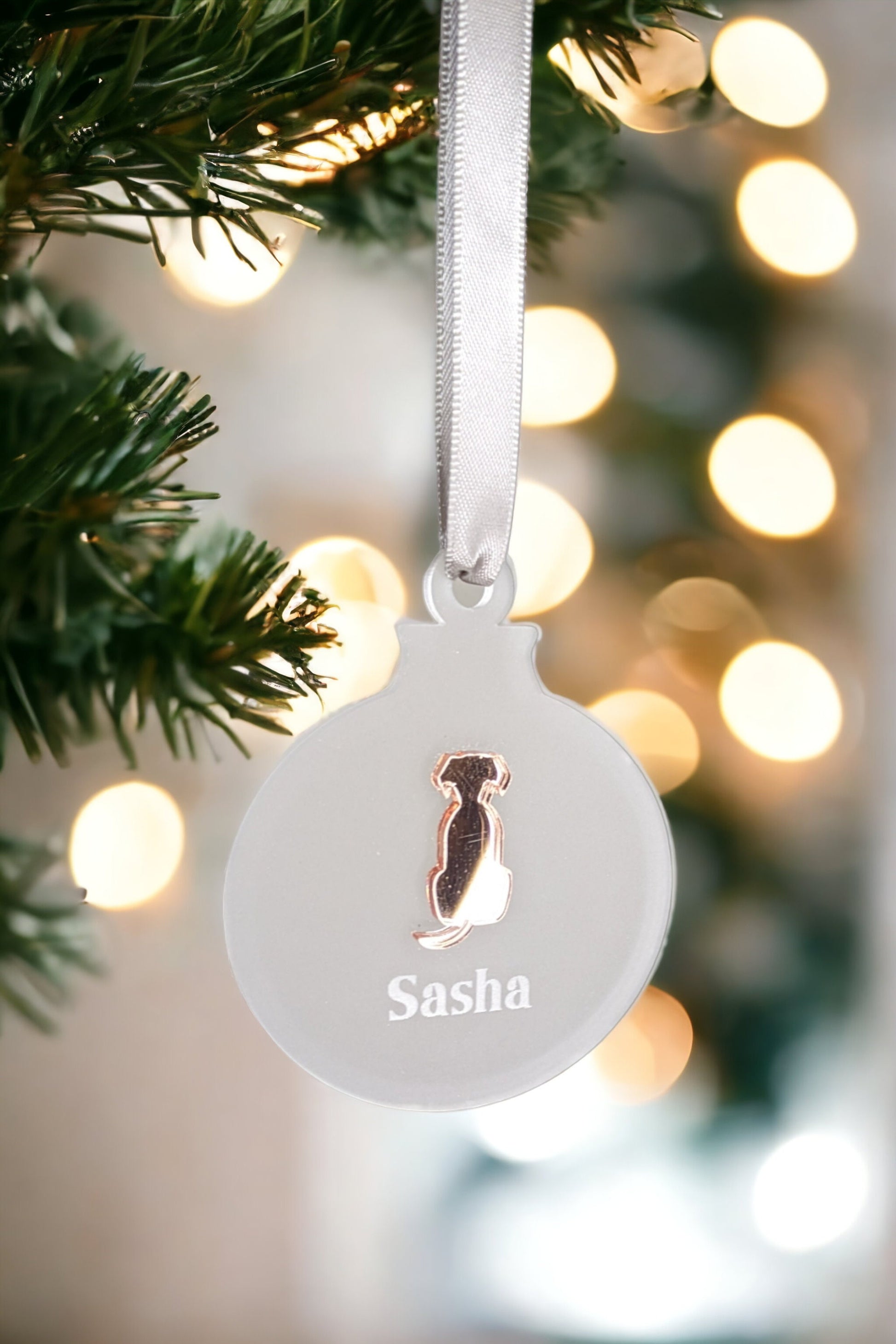 Frosted christmas bauble with dog name engraved. Cut rose gold dog silhouette is attached in the middle. 