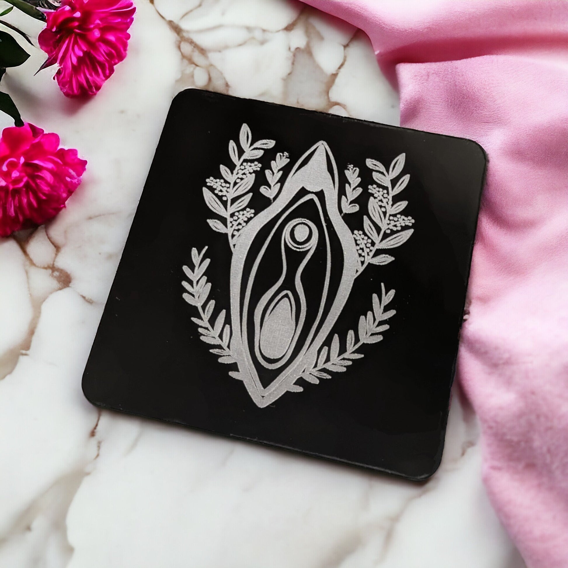 Sleek black wine coaster. Made with a lovely women empowerment design. Featuring a floral vagina in the middle