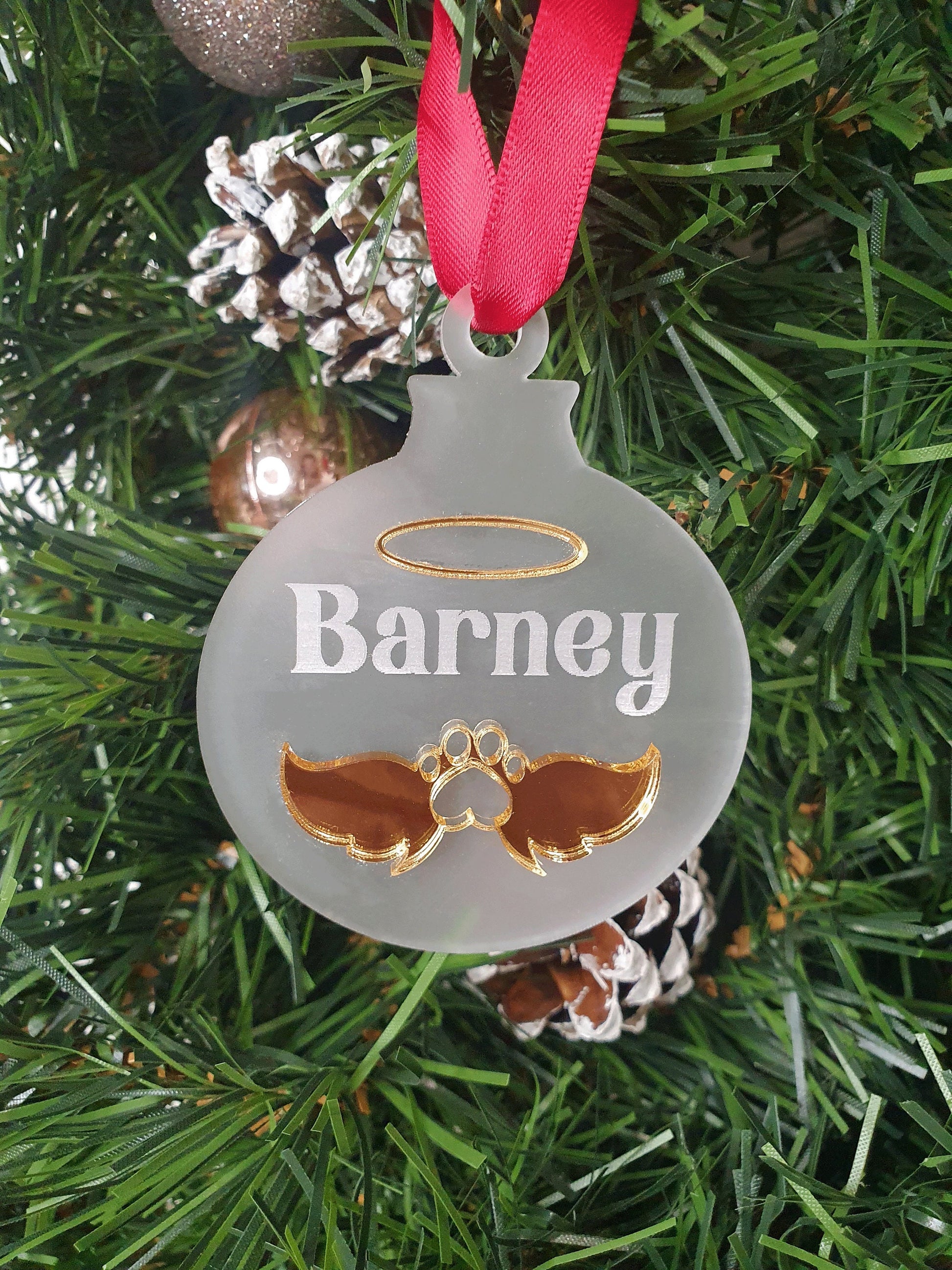 a gold memorial bauble for a dog. With the dogs name barney engraved in to the ornament. 