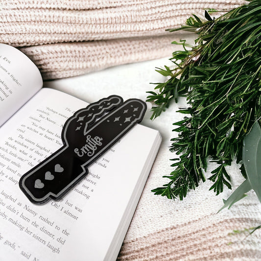 bold personalised black bookmark in the shape of a vibrator. Rabbit ear vibrator shaped book gift on an open book